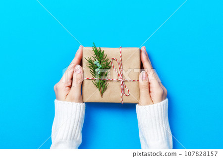 Female hands holding gift box on Blue background Female hands holding gift box on Blue background 107828157