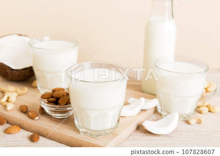Set or collection of various vegan milk almond, coconut, cashew, on table background. Vegan plant based milk and ingredients, top view Set or collection of various vegan milk almond, coconut, cashew, on table background. Vegan plant based milk and ingredients, top view 107828607