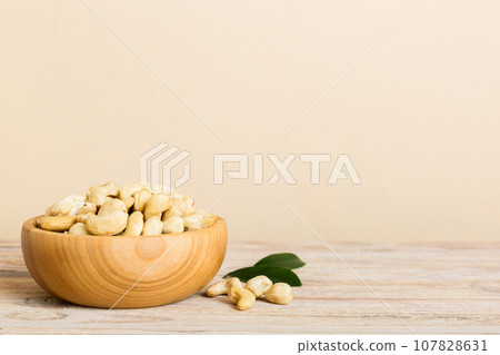cashew nuts in wooden bowl on table background. top view. Space for text Healthy food 107828631