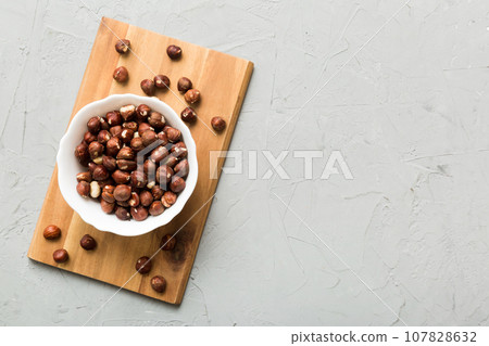 Wooden bowl full of hazelnuts on table background. Healthy eating concept. Super foods 107828632