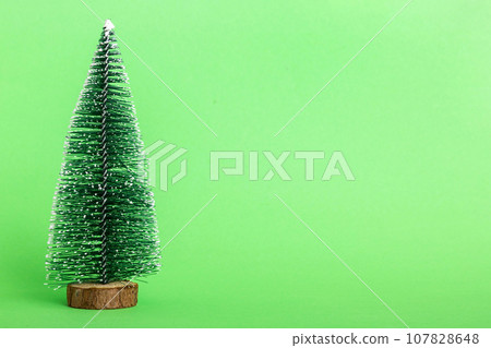 One small Christmas tree on colored background. new year decoration with copy space 107828648