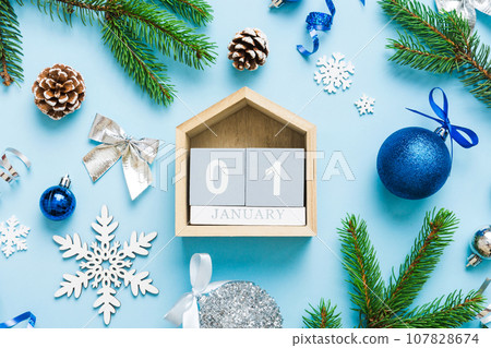 Christmas calendar 1 january. Christmas gift, fir branches, pine cones. Flat lay, top view. New Year decorations on a colored background Christmas calendar 1 january. Christmas gift, fir branches, pine cones. Flat lay, top view. New Year decorations on a colored background 107828674
