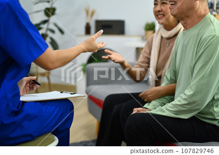 Practitioner nurse explaining therapy details to elderly patient. Assistance and rehabilitation 107829746