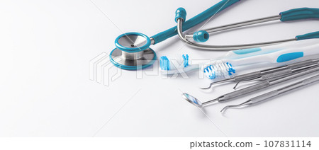 Dentist tools and toothbrush on white background, dental care and treatment, copy space Dentist tools and toothbrush on white background, dental care and treatment, copy space 107831114