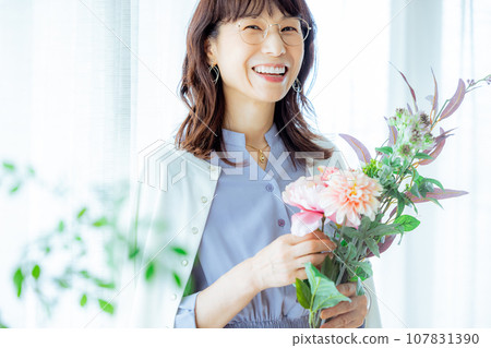Middle-aged woman with a bouquet of flowers Middle-aged woman with a bouquet of flowers 107831390