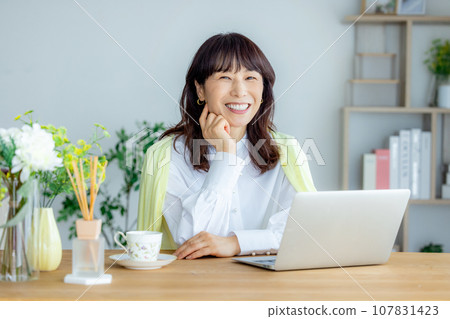 A woman using a computer in the living room A woman using a computer in the living room 107831423
