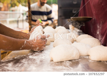 Men's hands knead yeast dough for baking bread Men's hands knead yeast dough for baking bread 107832297