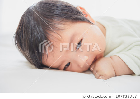 Baby raising his head from lying down 107833318