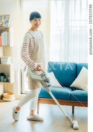 A woman cleaning a vacuum cleaner 107833596