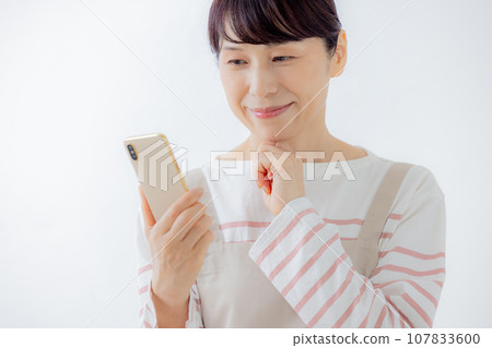 A housewife watching a smartphone 107833600