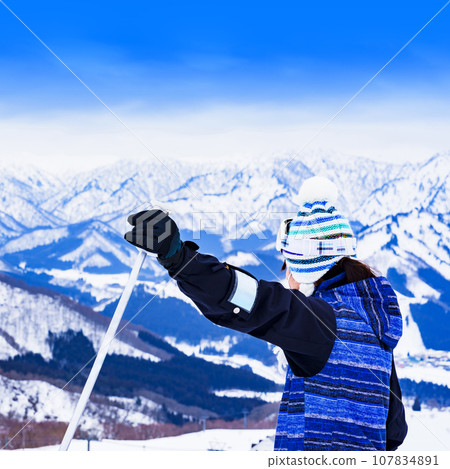 A young skier who enjoys skiing at a ski resort [ image of winter sports ] 107834891