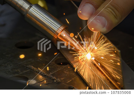 Close up scene the laser welding process with the sparking light. Close up scene the laser welding process with the sparking light. 107835008