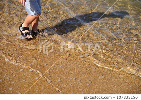 child's feet playing on the beach child's feet playing on the beach 107835150