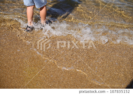 child's feet playing on the beach child's feet playing on the beach 107835152