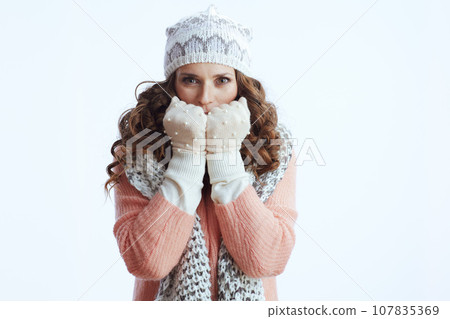 sad trendy woman warming hands with breath on white 107835369