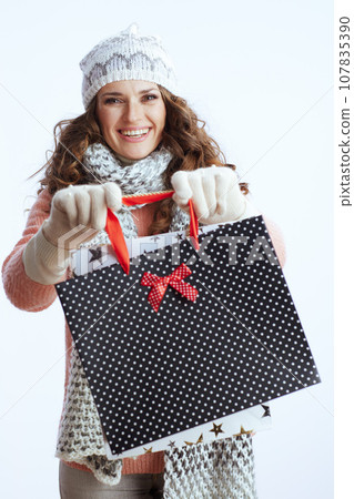 smiling woman in sweater, mittens, hat and scarf on 107835390