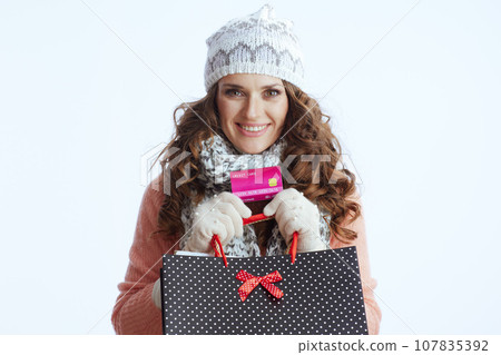 happy trendy woman in sweater, mittens, hat and scarf 107835392