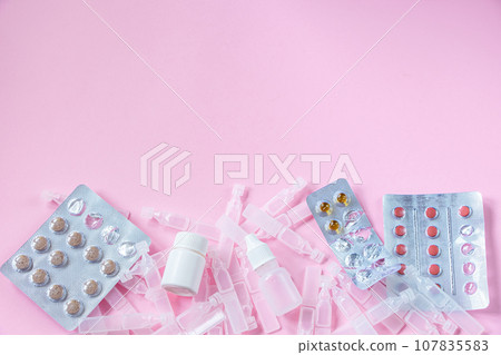 Medications and medical ampoules on pink background. 107835583
