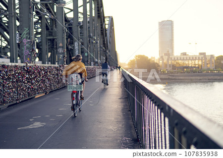People ride bicycles on the Hohenzollern Bridge, Cologne 107835938