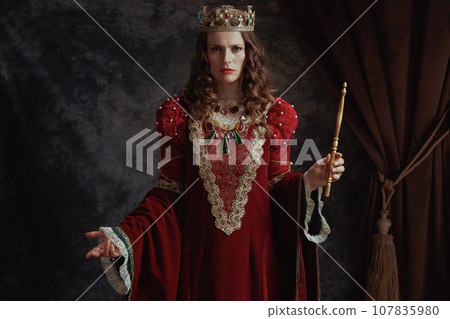 medieval queen in red dress with wand and crown medieval queen in red dress with wand and crown 107835980