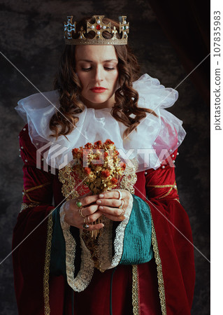 medieval queen in red dress with dried flower and white collar medieval queen in red dress with dried flower and white collar 107835983