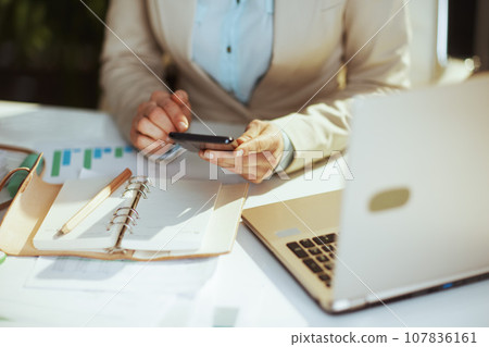Modern accountant woman in green office using phone Modern accountant woman in green office using phone 107836161
