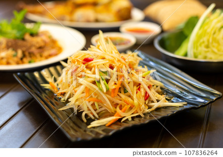 Thai food papaya salad (Som Tum) on a wooden table Thai food papaya salad (Som Tum) on a wooden table 107836264