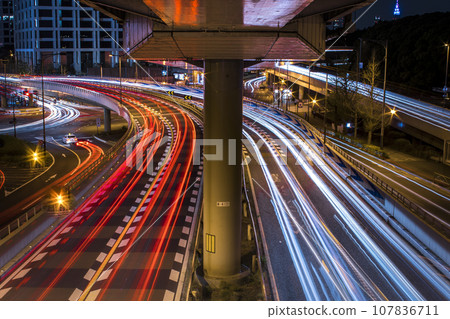 Light trails of illuminated cars at night seen from the pedestrian bridge at night Light trails of illuminated cars at night seen from the pedestrian bridge at night 107836711