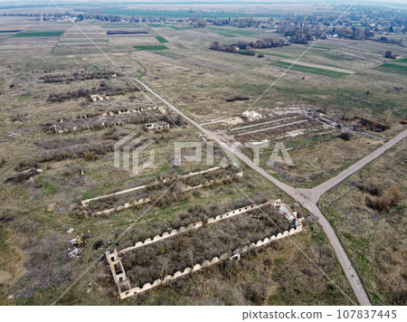 Destroyed agricultural buildings, aerial view. Abandoned livestock farm. Destroyed agricultural buildings, aerial view. Abandoned livestock farm. 107837445