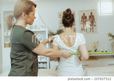 therapist woman in massage cabinet conducting examination 107837522