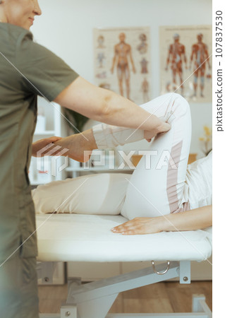 Therapist woman in massage cabinet conducting examination Therapist woman in massage cabinet conducting examination 107837530