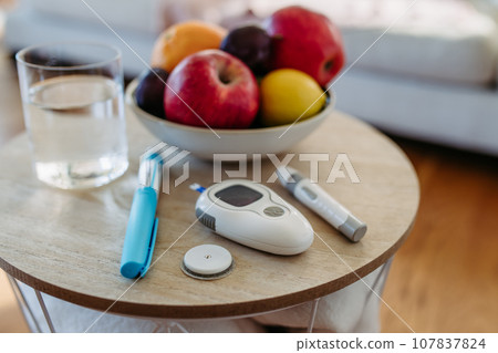 Close up of diabetes supplies and devices on table. Continuous glucose monitor, insulin pen, blood glucose meter. Image with copy space. Close up of diabetes supplies and devices on table. Continuous glucose monitor, insulin pen, blood glucose meter. Image with copy space. 107837824