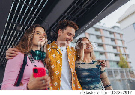 Generation z students hanging out together outdoors in the city. Low angle shot with copy space. Generation z students hanging out together outdoors in the city. Low angle shot with copy space. 107837917
