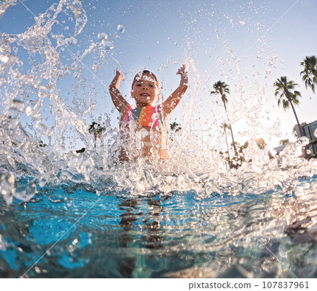 Little girl splashing water in the pool, playing in the water, having fun. Beach resort vacation by sea. Winter or summer seaside holiday. Little girl splashing water in the pool, playing in the water, having fun. Beach resort vacation by sea. Winter or summer seaside holiday. 107837961
