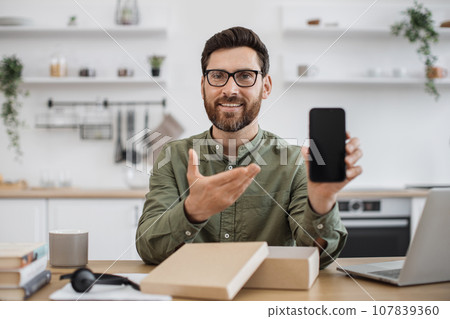 Male influencer unpacking new smartphone and live streaming 107839360
