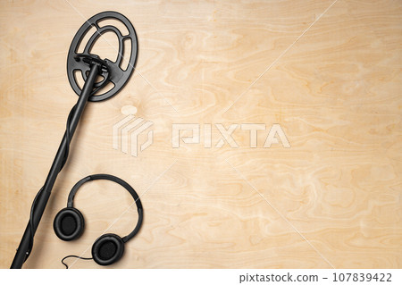 Metal detector on wooden background top view Metal detector on wooden background top view 107839422