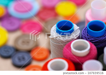 Many colored spools of threads as a background Many colored spools of threads as a background 107839516