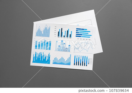 Financial paper with charts and diagrams on gray table Financial paper with charts and diagrams on gray table 107839634