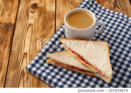 Triangle toasted sandwich on wooden board close up Triangle toasted sandwich on wooden board close up 107839874