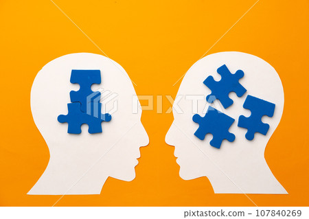 Papercut head silhouette with puzzle pieces on yellow background 107840269