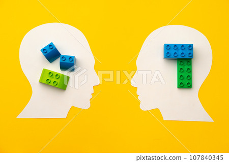 Papercut head silhouette with toy constructor pieces on yellow background Papercut head silhouette with toy constructor pieces on yellow background 107840345