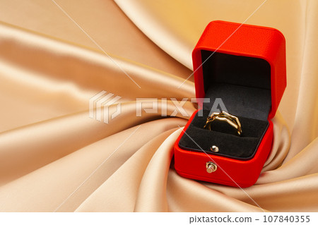 Golden ring in red jewelry box close up 107840355