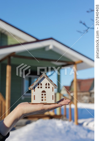 woman holds key and a model of mock-up of house in her hands. sale of real estate construction woman holds key and a model of mock-up of house in her hands. sale of real estate construction 107840408