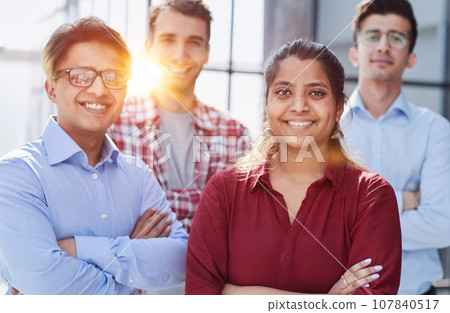 Theyre all about their business. Shot of a group of businesspeople standing in an office at work. Theyre all about their business. Shot of a group of businesspeople standing in an office at work. 107840517