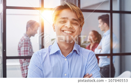 Portrait of a confident young businessman posing with his arms Portrait of a confident young businessman posing with his arms 107840553