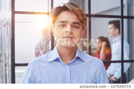 Portrait of a man in a blue shirt looking at the camera. 107840559