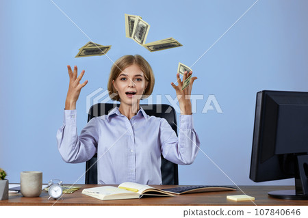 businesswoman throwing money while sitting on chair at desk. businesswoman throwing money while sitting on chair at desk. 107840646