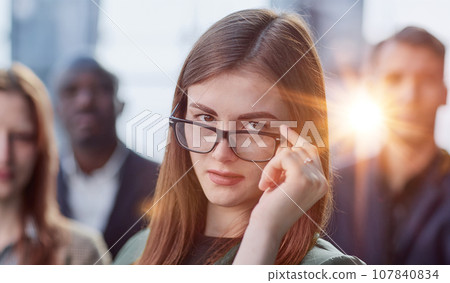 Portrait of a young serious business woman with colleagues 107840834