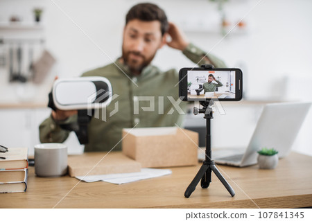 Male showing virtual reality glasses and filming on mobile Male showing virtual reality glasses and filming on mobile 107841345
