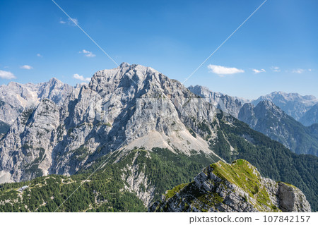 Vrsic Pass and Prisojnik, or Prisank, Mountain. Sunny day in Julian Alps, Slovenia Vrsic Pass and Prisojnik, or Prisank, Mountain. Sunny day in Julian Alps, Slovenia 107842157